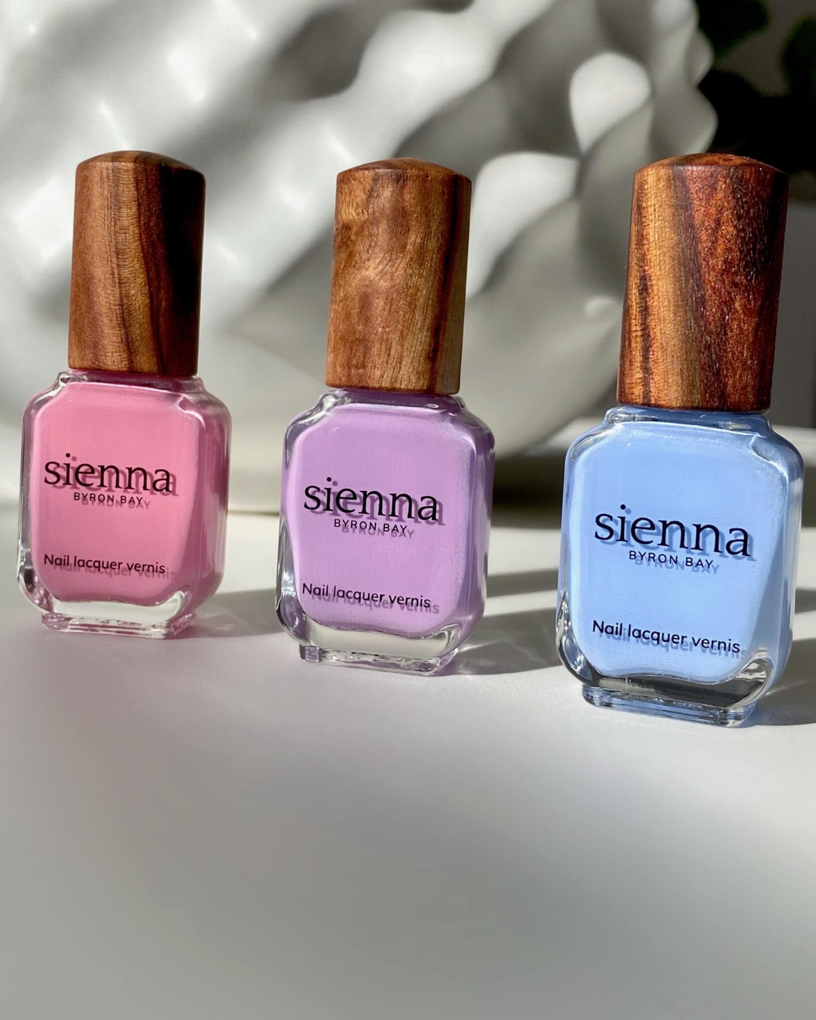 pink purple and blue nail polish bottles with timber cap by sienna