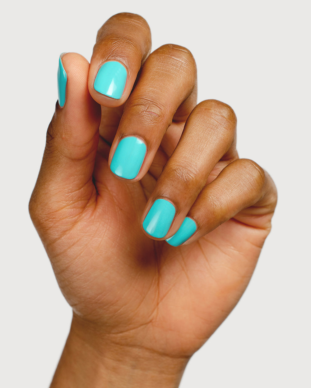 Turquoise aqua nail polish hand swatch on medium skin tone