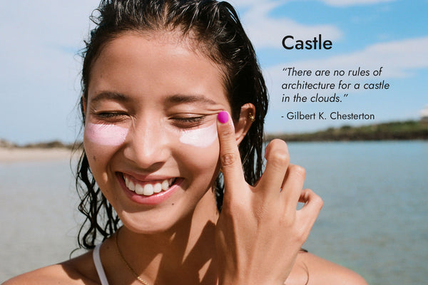 Happy woman with fair skin wearing Queen purple nail polish at Byron Bay beach, with Castle text and quote on image.