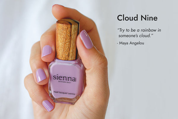 Hand with fair skin tone wearing Karma purple nail polish and CLoud Nine text with quote.