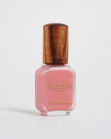 peachy pink nail polish in a bottle with a timber lid