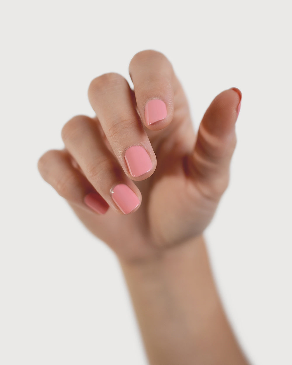 peachy pink nail polish hand swatch on fair skin tone