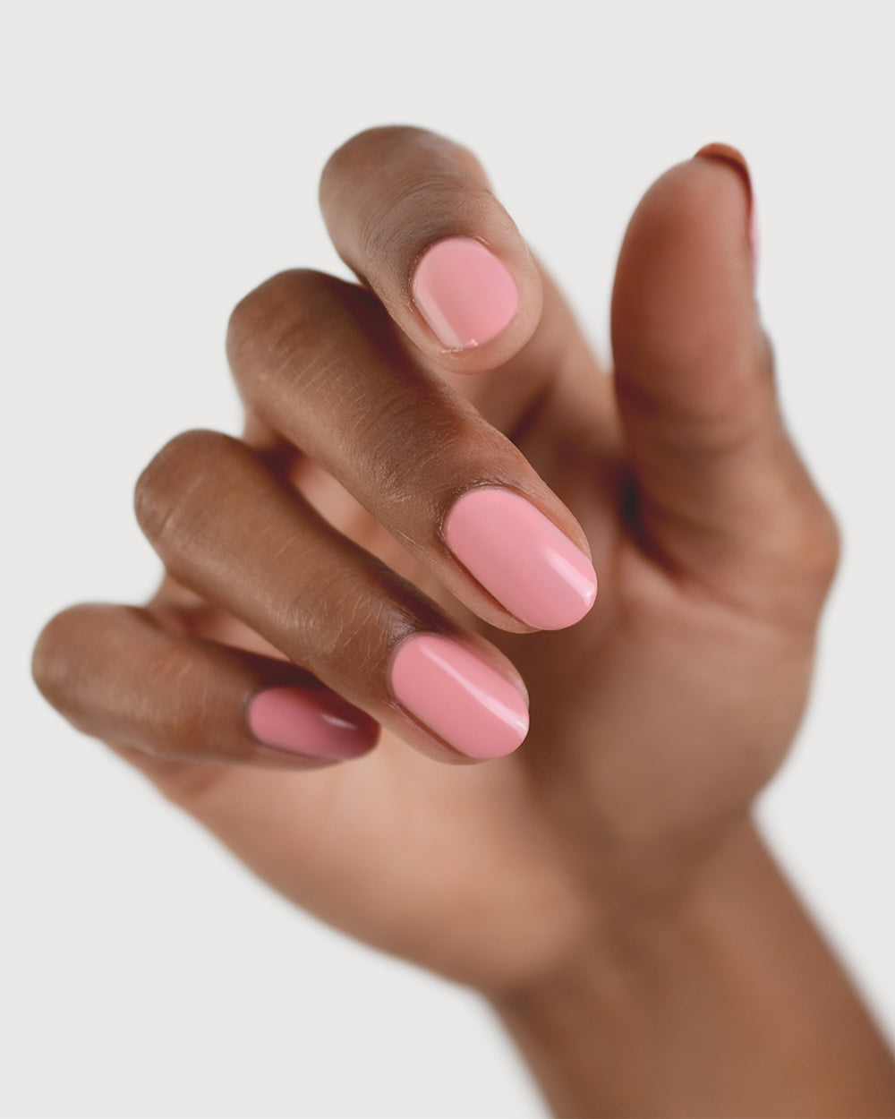 peachy pink nail polish hand swatch on medium skin tone