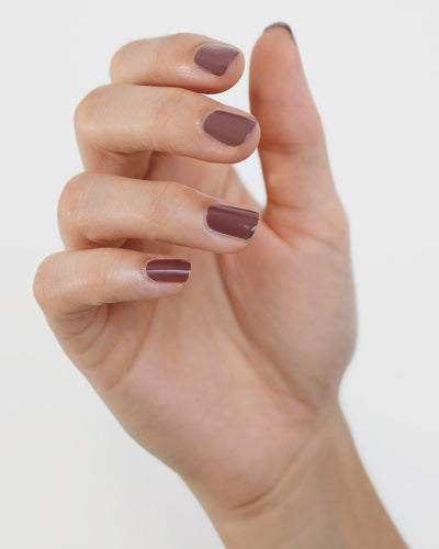 Fair skin tone hand wearing Grounded mylk chocolate crème nail polish by Sienna Byron Bay 