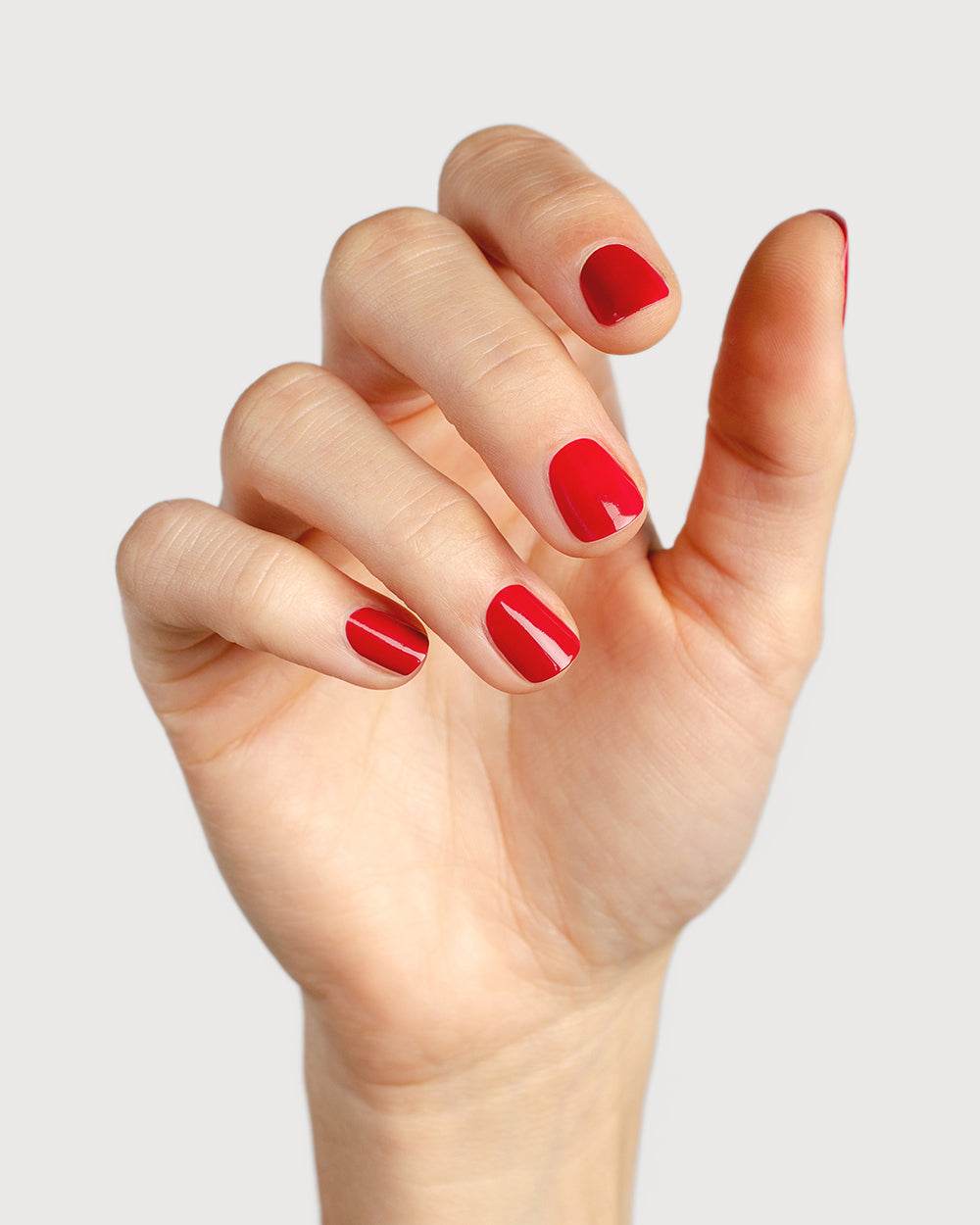 classic red nail polish hand swatch on medium skin tone 