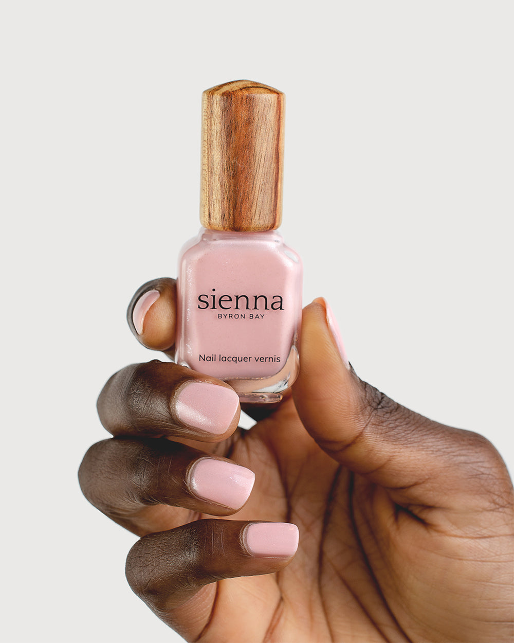 Shimmering Cherry Blossom Nail Polish on Dark Skin Tone with Sienna Bottle