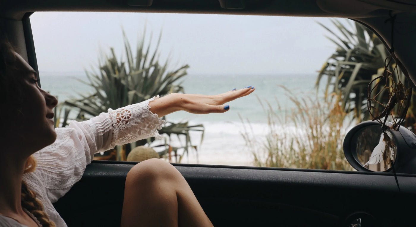 woman holding hand outside car window wearing blue nail polish by sienna