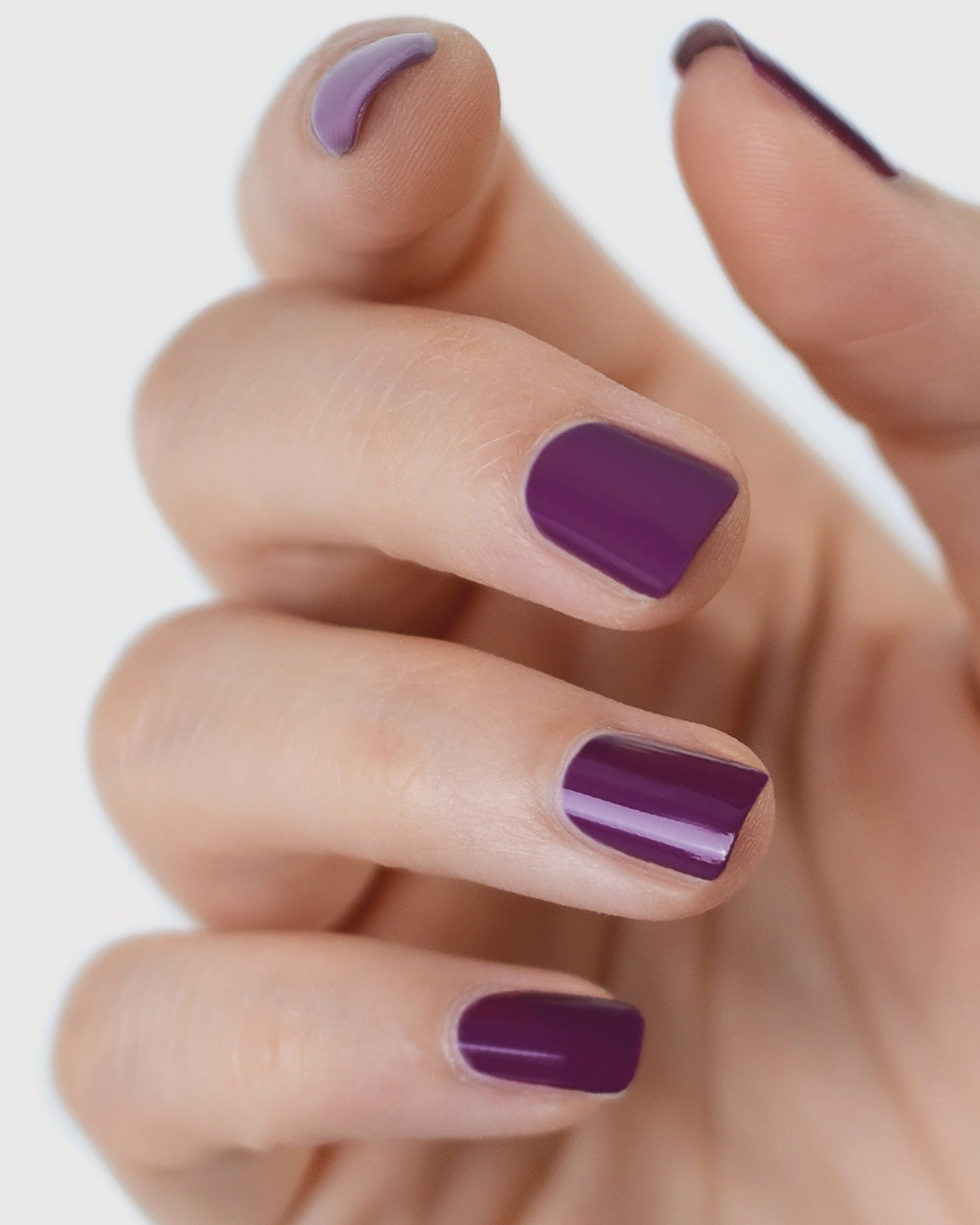 Reverence Violet Grape Crème nail polish by Sienna Byron Bay on fair skin tone hand.