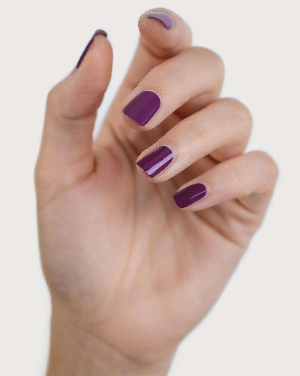 Reverence Violet Grape Crème nail polish by Sienna Byron Bay on fair skin tone hand.