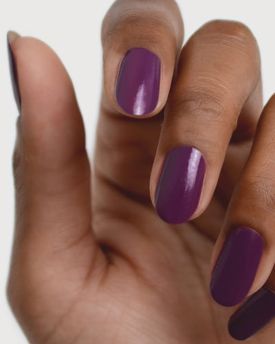 Reverence Violet Grape Crème nail polish by Sienna Byron Bay on medium skin tone hand.