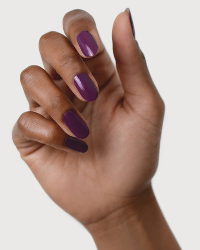 Reverence Violet Grape Crème nail polish by Sienna Byron Bay on medium skin tone hand.