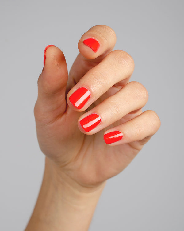 Warm red nail polish hand swatch on fair skin tone by sienna
