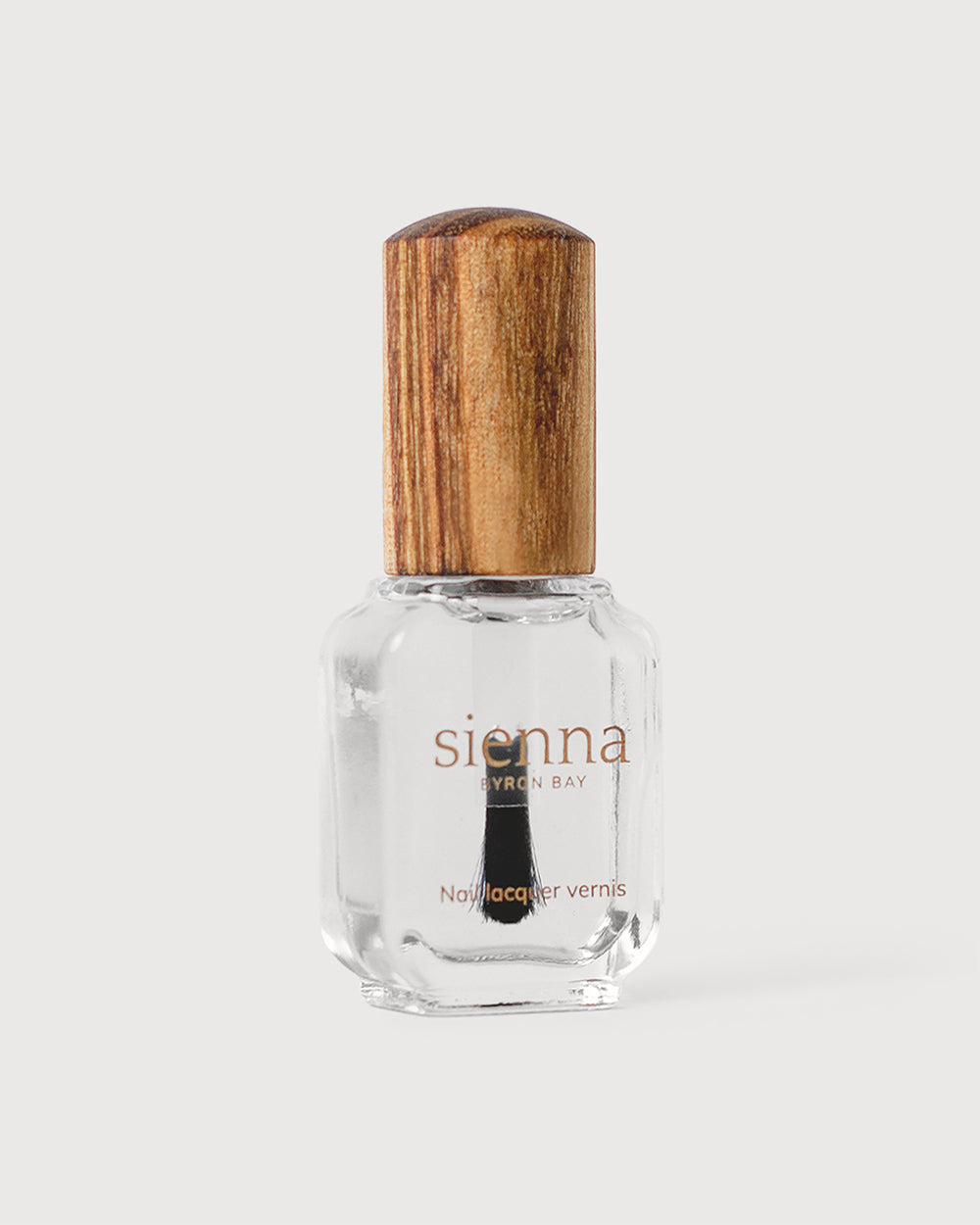Transparent base and top coat in glass bottle with timber cap