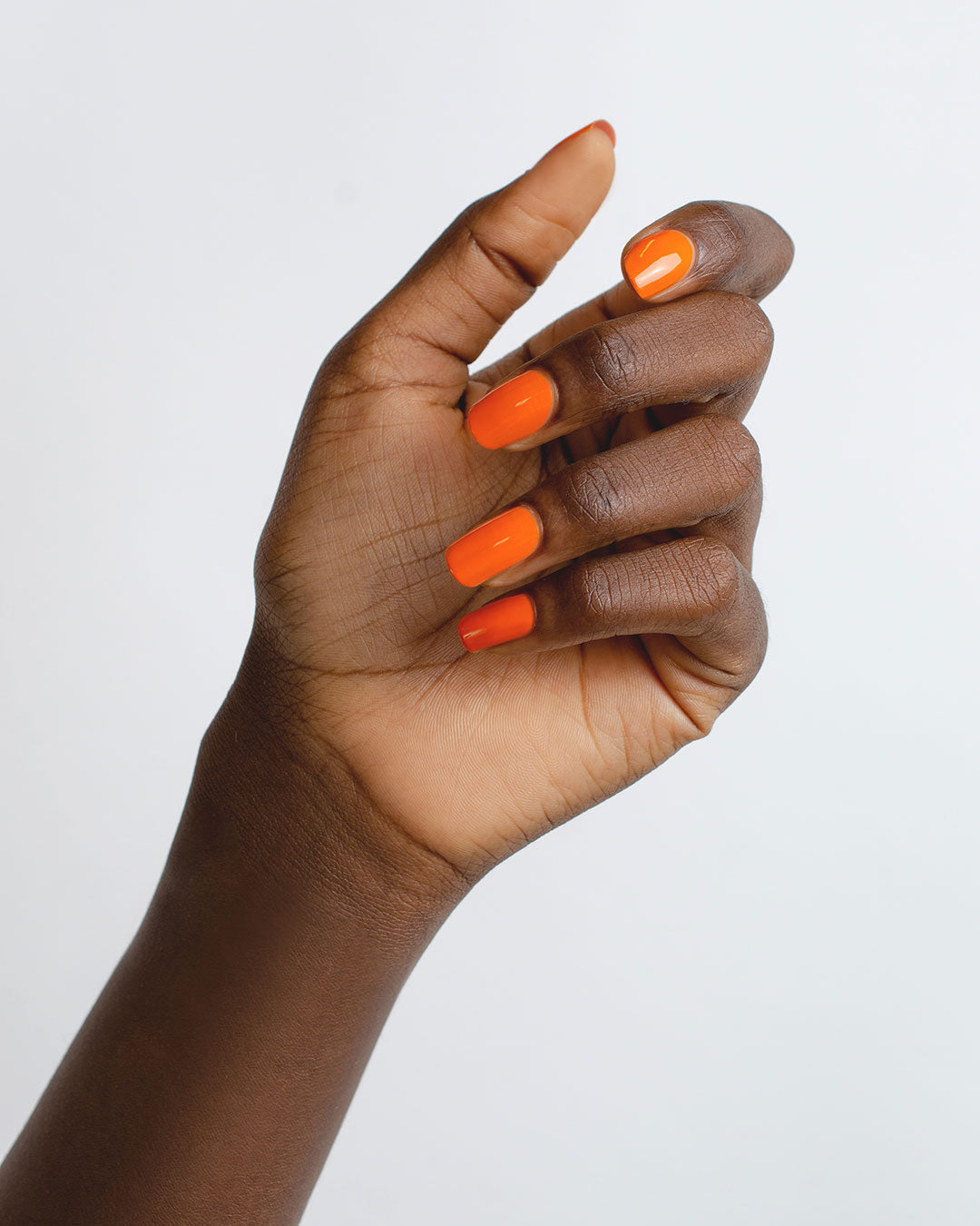 Bright papaya Orange nail polish swatch on dark skin tone by Sienna Byron Bay