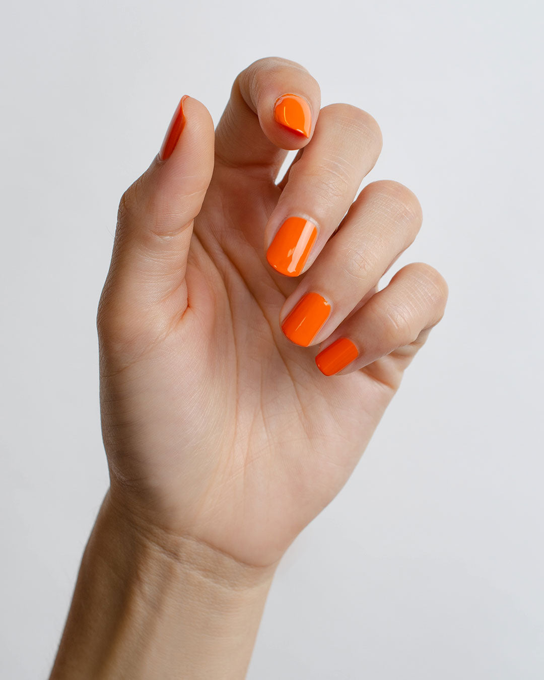 Bright papaya Orange nail polish swatch on fair skin tone by Sienna Byron Bay