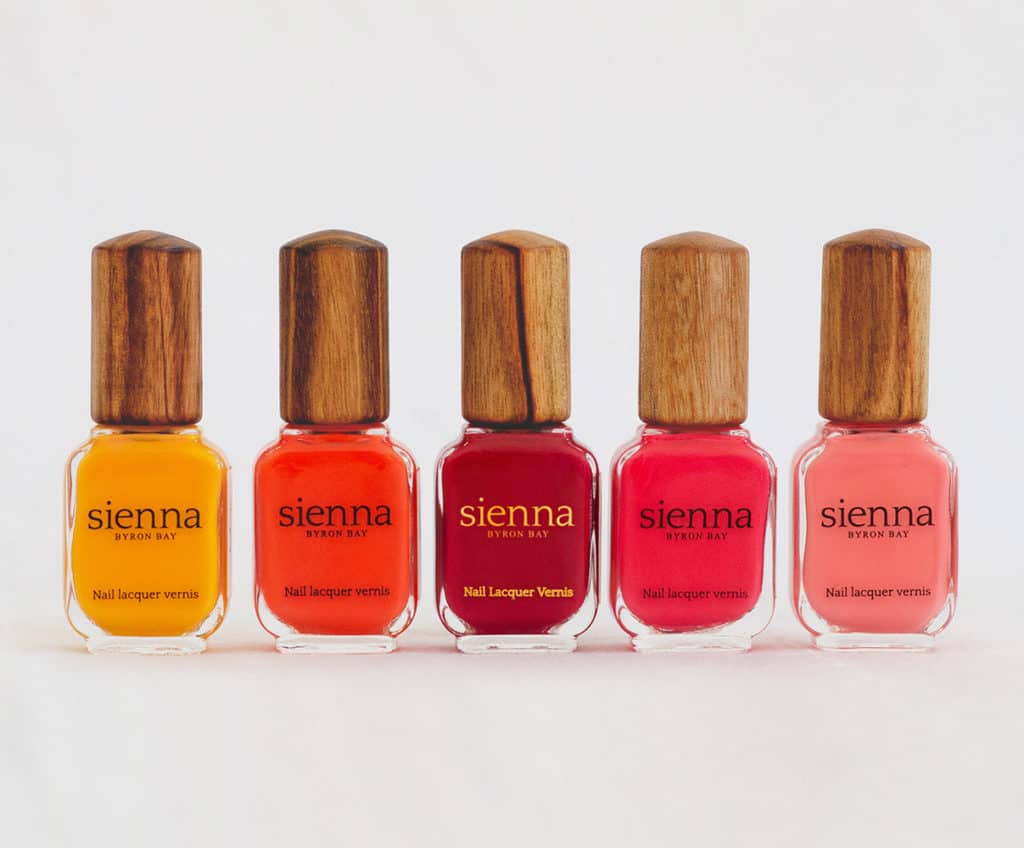 yellow orange red and bright pink nail polish in glass bottle by sienna