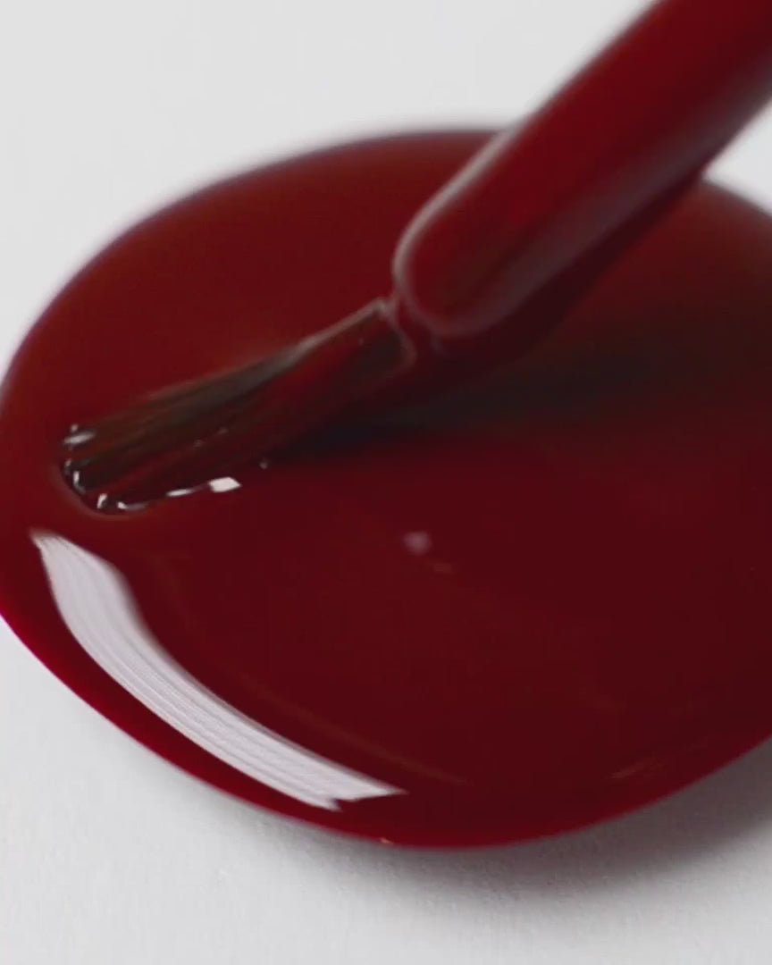 Organic mid-tone red nail polish swirl video with brush
