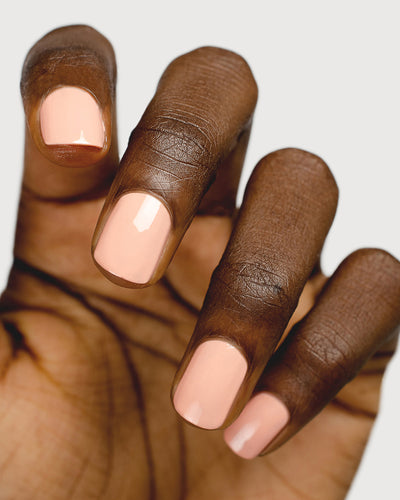 nude pink nail polish hand swatch on dark skin tone up close