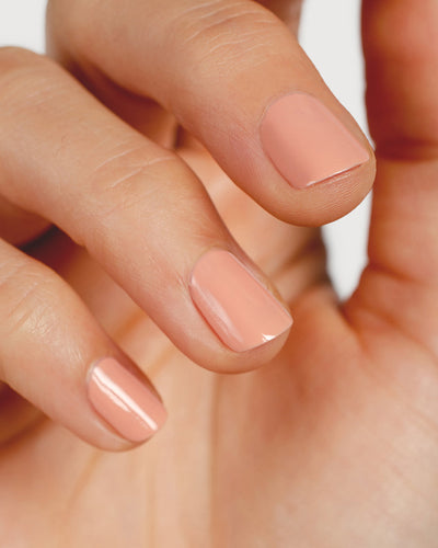 nude pink nail polish hand swatch on fair skin tone up close