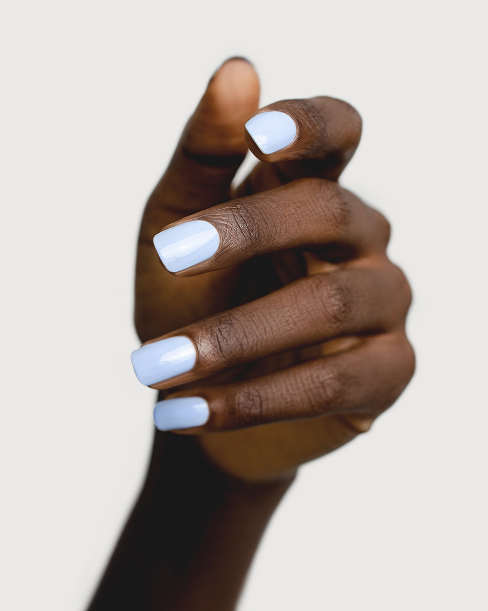 baby blue nail polish hand swatch on dark skin tone
