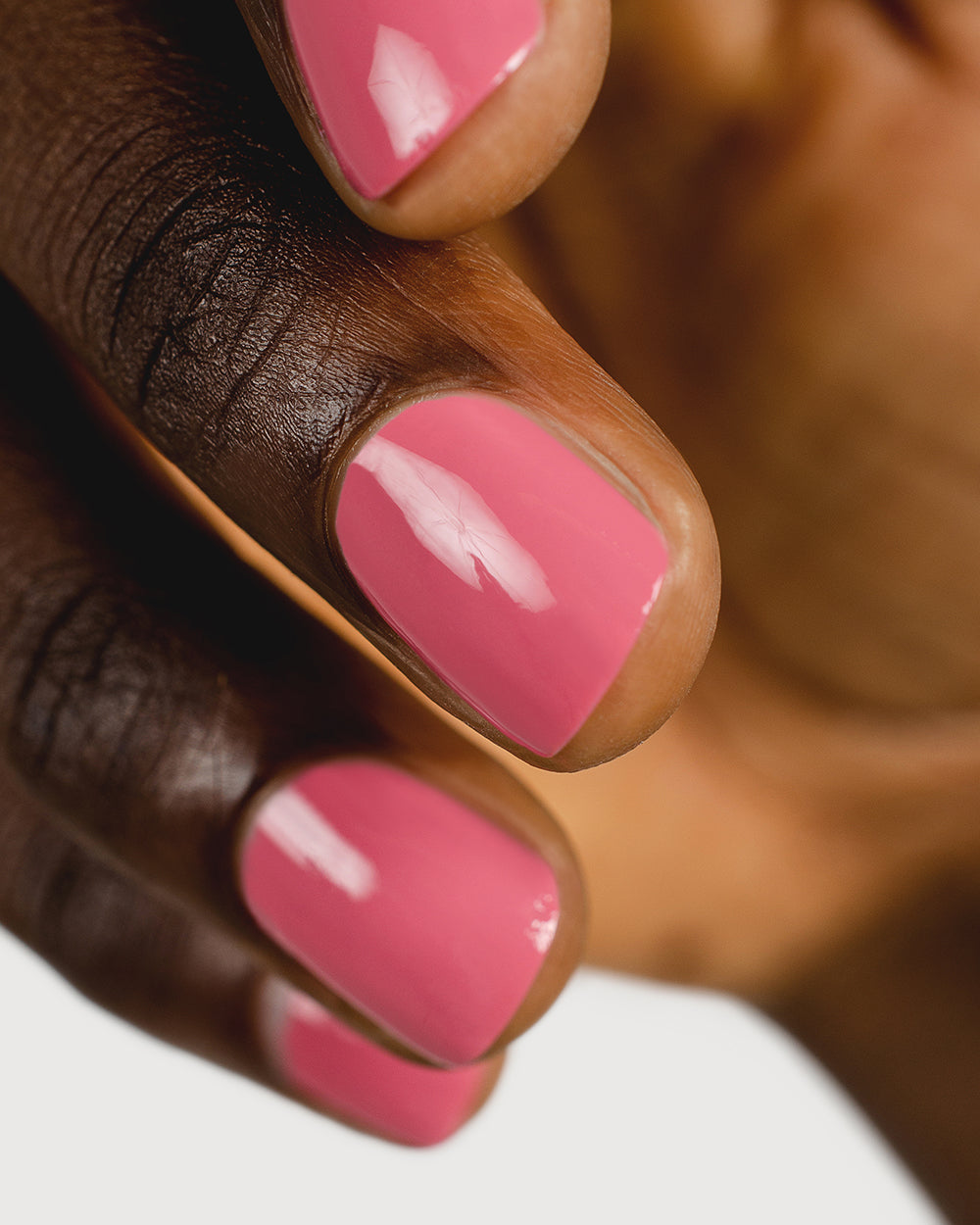 midtone pink nail polish hand swatch on dark skin tone up close