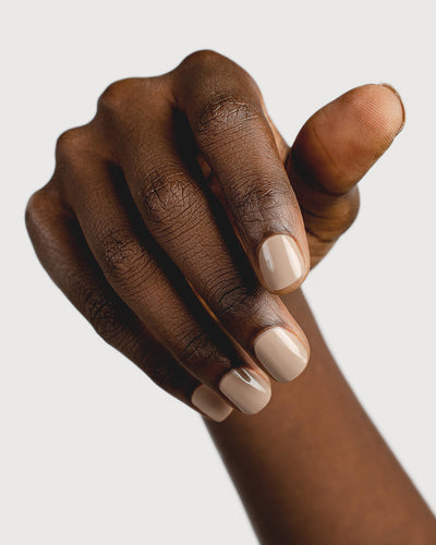 beige nail polish hand swatch on dark skin tone
