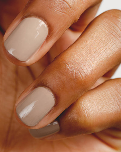 beige nail polish hand swatch on medium skin tone