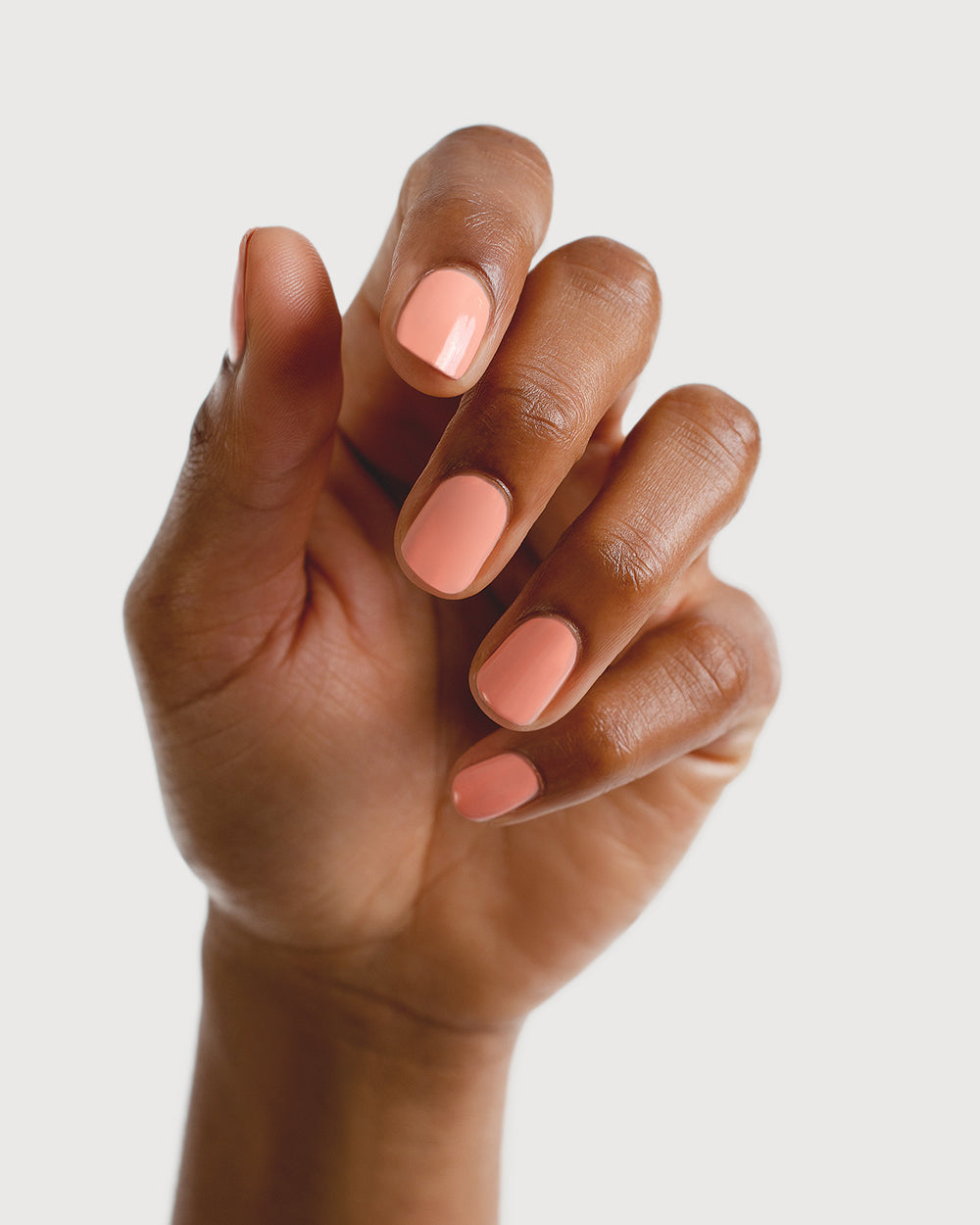 peach blush nail polish hand swatch on medium skin tone