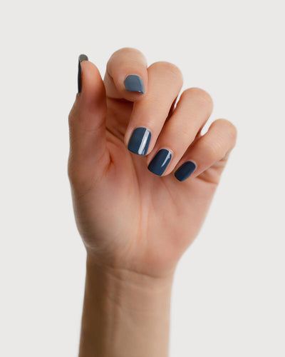 blue-grey nail polish hand swatch on fair skin tone