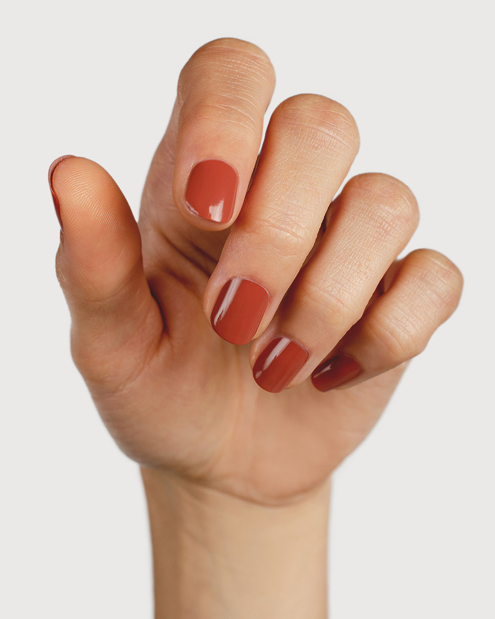 terracotta nail polish hand swatch on fair skin tone