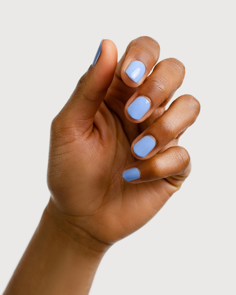 periwinkle blue nail polish hand swatch on medium skin tone