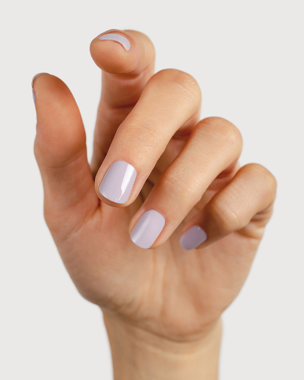 Pastel purple-grey nail polish hand swatch on fair skin tone
