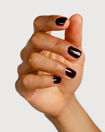 dark red nail polish hand swatch on medium skin tone