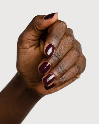Aubergine nail polish hand swatch on dark skin tone 