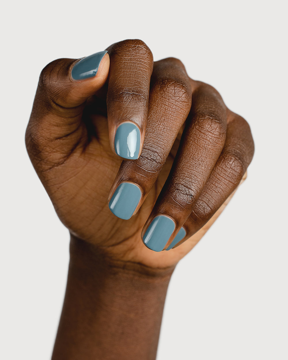 mid grey-blue nail polish hand swatch on dark skin tone