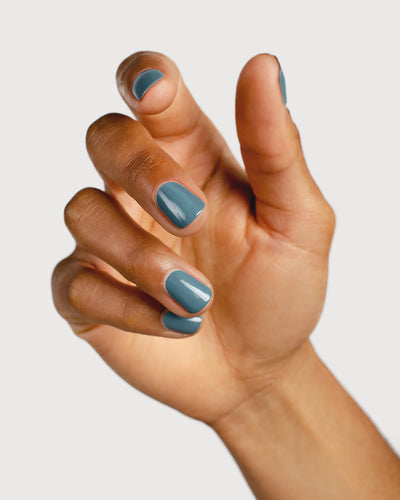mid grey-blue nail polish hand swatch on medium skin tone