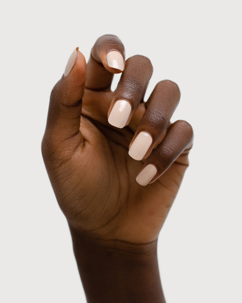 classic beige nail polish hand swatch on dark skin tone