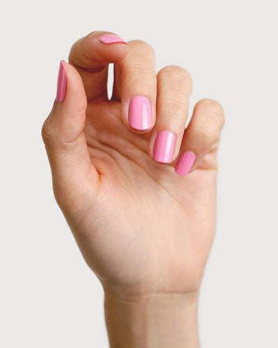 Classic lolly pink nail polish hand swatch on fair skin tone