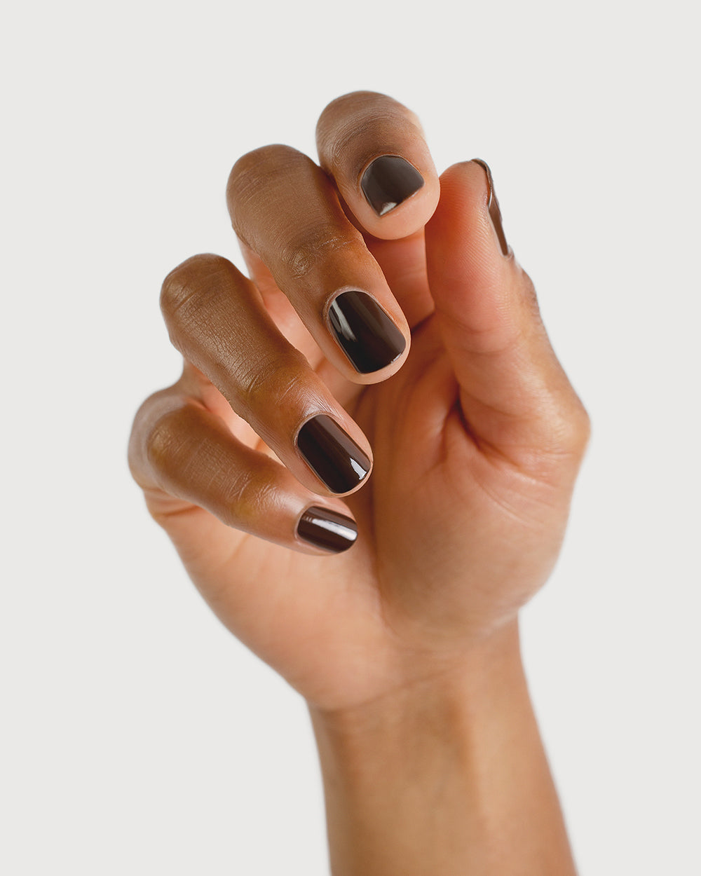 chocolate brown nail polish hand swatch on medium skin tone