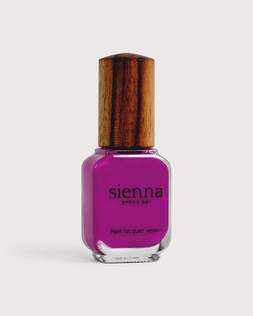 Bright magenta nail polish glass bottle with timber cap