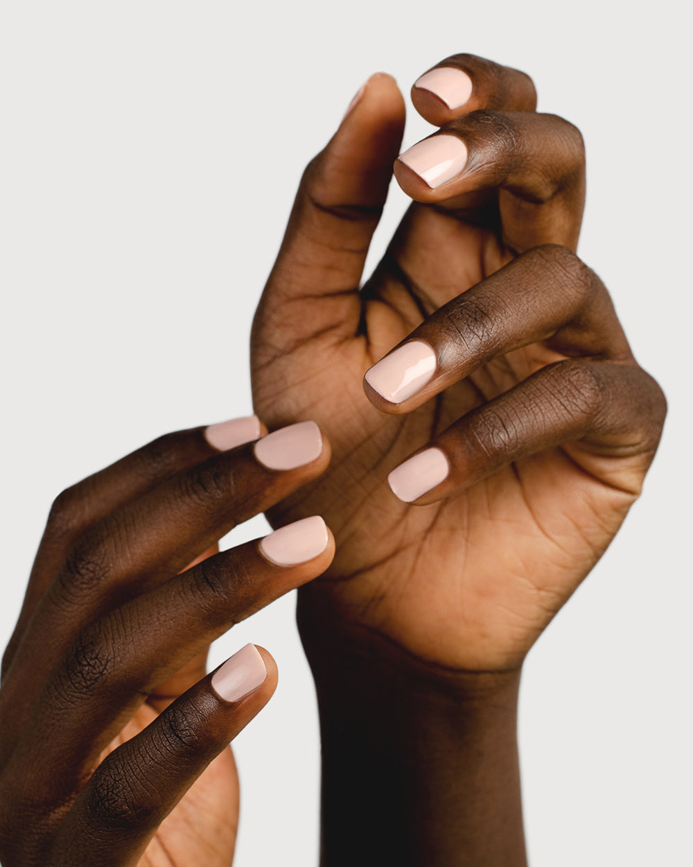 Light champagne pink nail polish hands swatch on dark skin tone