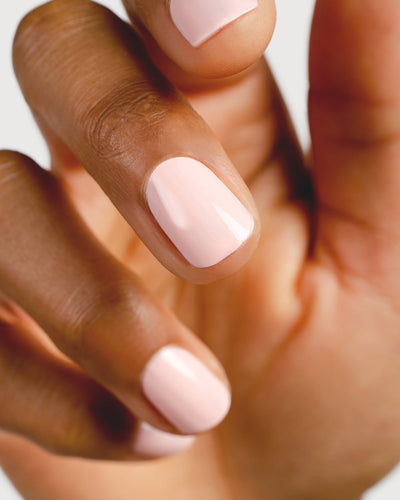 light champagne pink nail polish hand swatch on medium skin tone up close