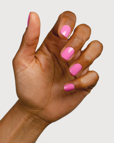 Bright mid-tone fuchsia nail polish hand swatch on medium skin tone