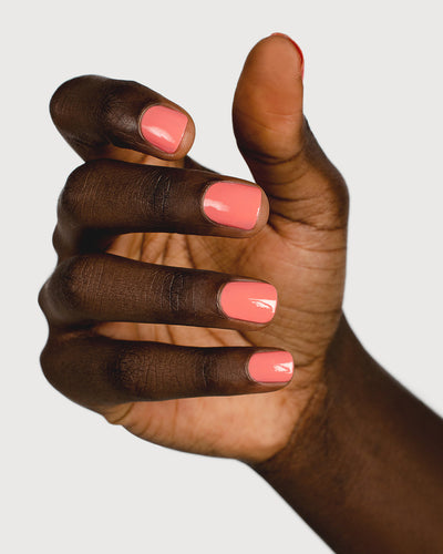 Pink peach nail polish hand swatch on dark skin tone