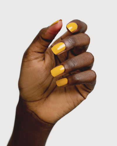 Tuscan sun yellow nail polish hand swatch on dark skin tone